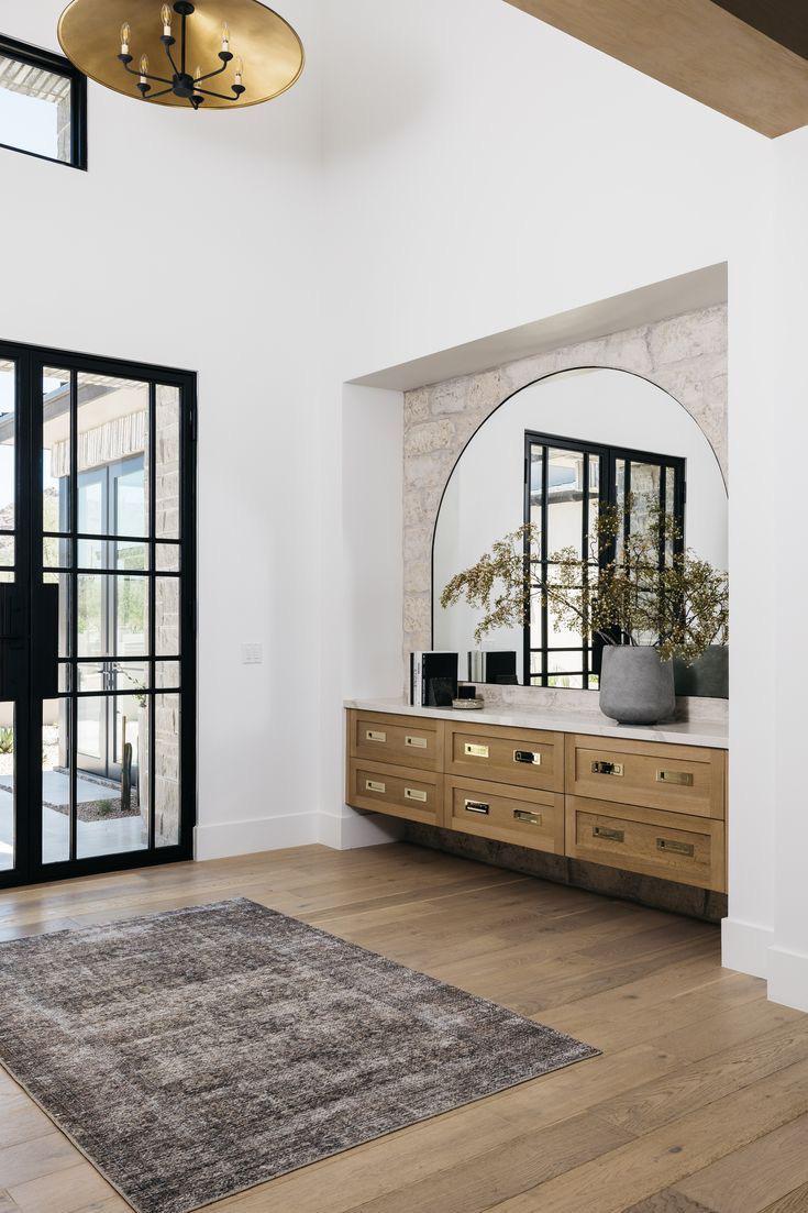 מבואת כניסה נעימה עם חומרים חמים, קווים גיאומטריים רגועים ותאורה מזמינה.